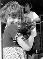 Jayne Berglund holds a baby pig by the door to the "nursery unit" at her family's farm near Kalona, Iowa.